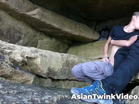 Youthful gay couple of diverse ethnicity engages in sexual activity in a serene lagoon setting